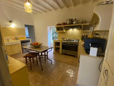 a kitchen with a table and a stove and a sink at Exceptionnelle Villa riad avec cuisinière-Piscine chauffée-Fibre internet in Marrakech
