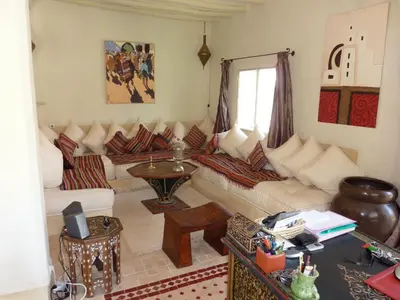 a living room with a couch and a table at Exceptionnelle Villa riad avec cuisinière-Piscine chauffée-Fibre internet in Marrakech