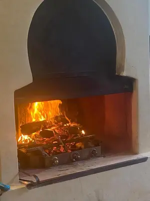 a brick oven with a fire inside of it at Exceptionnelle Villa riad avec cuisinière-Piscine chauffée-Fibre internet in Marrakech