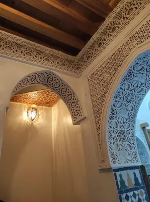 a room with two arched windows and a ceiling at Riad Averroès in Fès