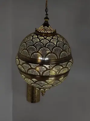 a black and gold lamp hanging from a wall at Riad Averroès in Fès