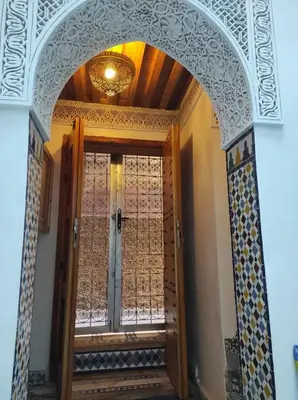an archway with a door in a building at Riad Averroès in Fès