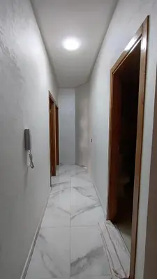 an empty hallway with a tile floor and a door at Oumnia12 in Fès