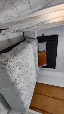 a bed with a white comforter and pillows at Oumnia12 in Fès