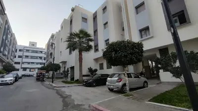 a parking lot with cars parked in front of a building at Oumnia12 in Fès