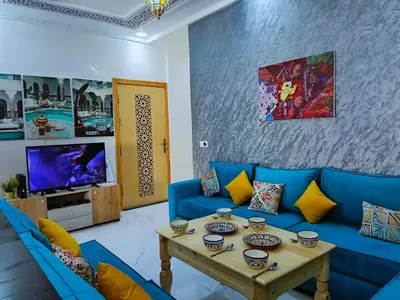 a living room with a blue couch and a table at شقه معاصره ب لمسة مغربيه في فاس in Fès