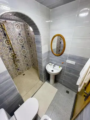 a bathroom with a sink and a toilet and a mirror at شقه معاصره ب لمسة مغربيه في فاس in Fès