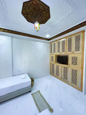 a living room with a bed and a tv at شقه معاصره ب لمسة مغربيه في فاس in Fès