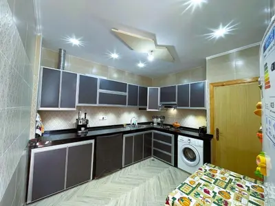 a kitchen with gray cabinets and a washer and dryer at شقه معاصره ب لمسة مغربيه في فاس in Fès