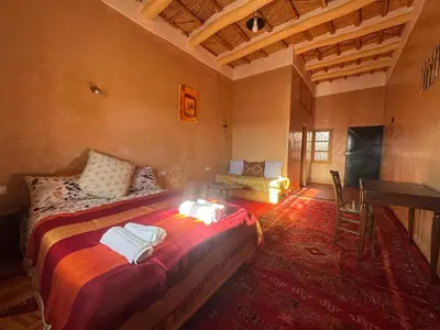 a bedroom with a bed and a desk in a room at KASBAH ALTAÏR in Kalaat MGouna