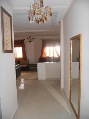 a living room with a mirror and a chandelier at Résidence Bab El Janoub in Ouarzazate