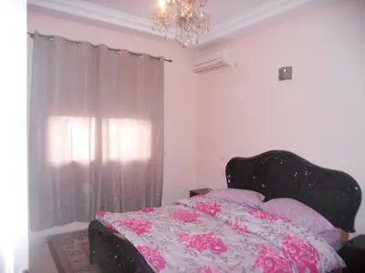 a bedroom with a bed and a chandelier at Résidence Bab El Janoub in Ouarzazate