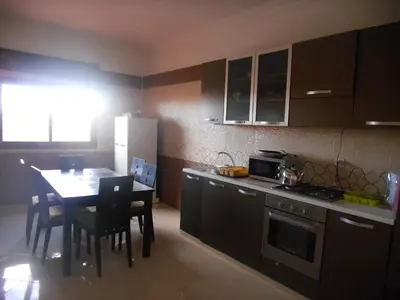 a kitchen with a table and a kitchen with a dining room at Résidence Bab El Janoub in Ouarzazate