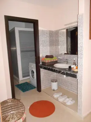 a bathroom with a sink and a mirror at Résidence Bab El Janoub in Ouarzazate