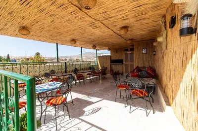 a patio with tables and chairs on a balcony at Riad Batha in Fès
