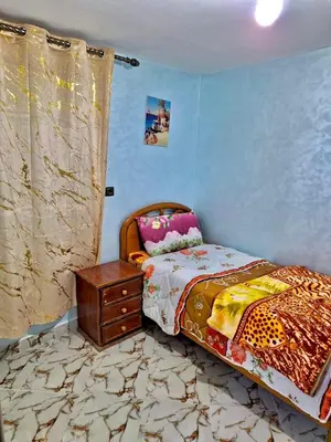 a bedroom with a bed and a dresser in it at Résidence SEHRAWILOCATION in Er Rachidia