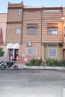 a motorcycle parked in front of a building at Résidence SEHRAWILOCATION in Er Rachidia