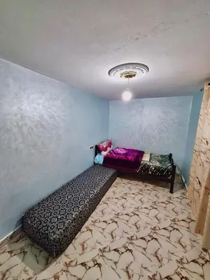 a room with a bed in the corner of a room at Résidence SEHRAWILOCATION in Er Rachidia