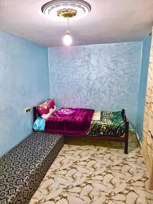 a room with a bed in the corner of a room at Résidence SEHRAWILOCATION in Er Rachidia