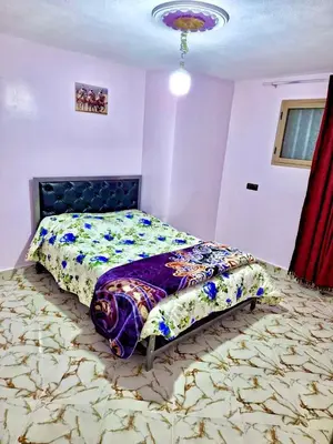 a bedroom with a bed with a floral comforter at Résidence SEHRAWILOCATION in Er Rachidia