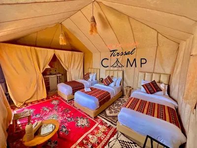 a group of four beds in a tent at Merzouga Tirssal Camp in Merzouga