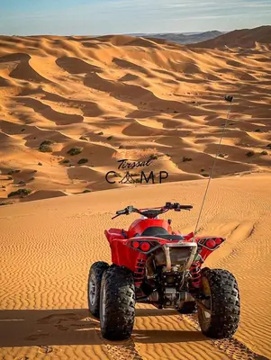a red atv parked in the desert at Merzouga Tirssal Camp in Merzouga