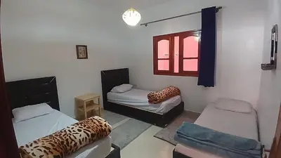 a room with two beds and a window at Warzazat Apartments in Ouarzazate