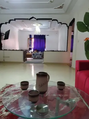 a living room with a glass table and a red couch at Warzazat Apartments in Ouarzazate
