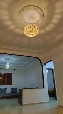 a room with a chandelier and a mirror on the ceiling at Warzazat Apartments in Ouarzazate