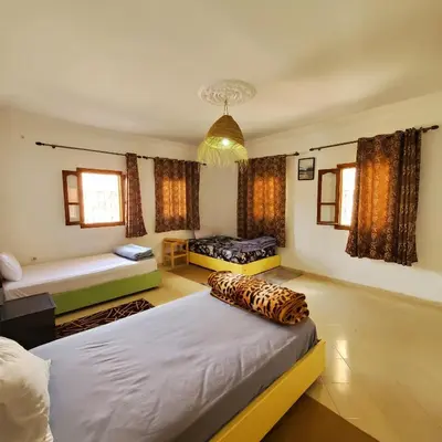 a bedroom with two beds and a chandelier at Warzazat Apartments in Ouarzazate