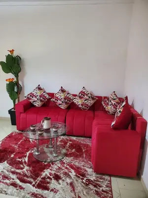 a red couch with pillows and a table in a living room at Warzazat Apartments in Ouarzazate