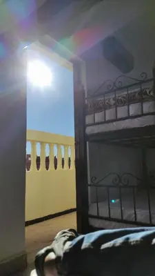a bedroom with a bunk bed with a rainbow in the window at WARZAZAT Hostel in Ouarzazate