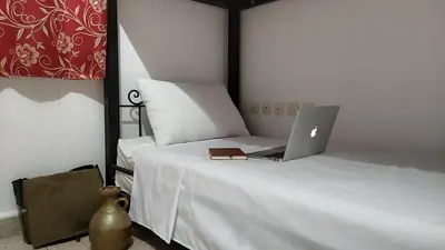 a bed with a laptop computer sitting on top of it at WARZAZAT Hostel in Ouarzazate