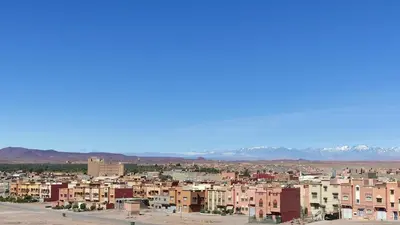 a city with buildings and mountains in the background at WARZAZAT Hostel in Ouarzazate