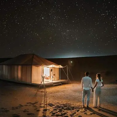a man and a woman standing in front of a tent at Sahara Berber Luxury Camp in Merzouga