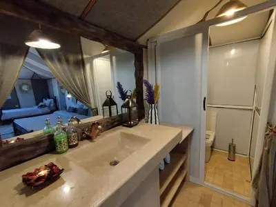 a bathroom with a sink and a large mirror at Sahara Berber Luxury Camp in Merzouga