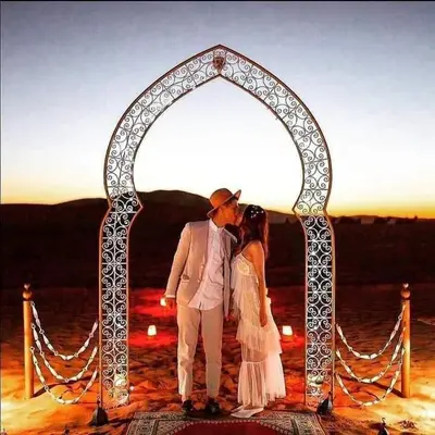 a man and a woman standing under an arch at Sahara Berber Luxury Camp in Merzouga