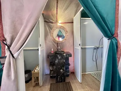 a room with a mirror and a table and curtains at Sahara Berber Luxury Camp in Merzouga