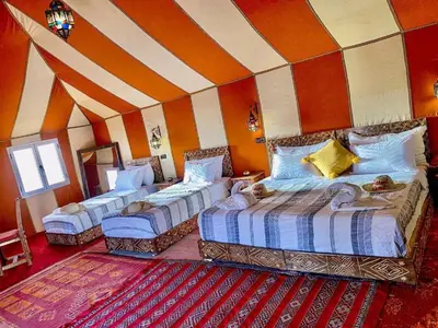 a bedroom with three beds in a room at Sahara Berber Luxury Camp in Merzouga