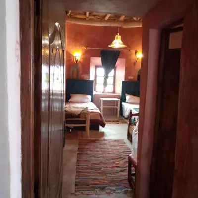 a bedroom with two beds and a room with a window at Dar adiafa dar asalam in Aït Ben Haddou