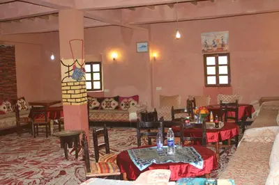 a large room with tables and chairs and a couch at Dar adiafa dar asalam in Aït Ben Haddou