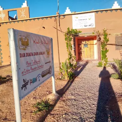 a shadow of a sign in front of a building at Dar adiafa dar asalam in Aït Ben Haddou