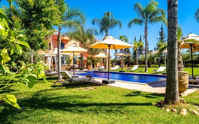 a backyard with a pool with umbrellas at Dar Biona in Marrakech