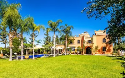 an exterior view of a mansion with palm trees at Dar Biona in Marrakech