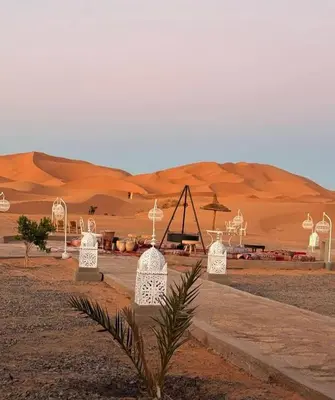 a desert area with a tent in the desert at Merzouga Night Camp in Merzouga