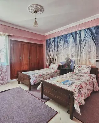 a bedroom with two beds and a mural on the wall at logement exceptionnel réservé aux familles in Meknès