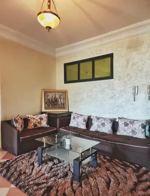a living room with a couch and a table at logement exceptionnel réservé aux familles in Meknès