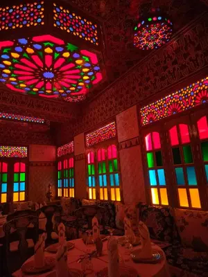 a dining room with colorful windows and tables at Riad Laraichi Palace Suites in Fès