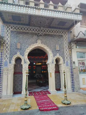 an entrance to a building with a red rug in front at Riad Laraichi Palace Suites in Fès