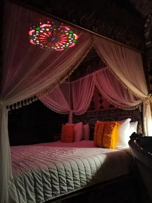 a bedroom with a canopy bed with a stained glass window at Riad Laraichi Palace Suites in Fès